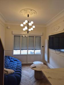 a living room with a blue couch and a chandelier at Appartement duplex Granville in Granville