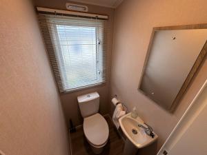a small bathroom with a toilet and a sink at Sun & Sand, Near Padstow, Seven Bays, Sleeps 6 in Saint Merryn