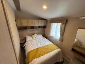 a small bedroom with a bed and a window at Sun & Sand, Near Padstow, Seven Bays, Sleeps 6 in Saint Merryn