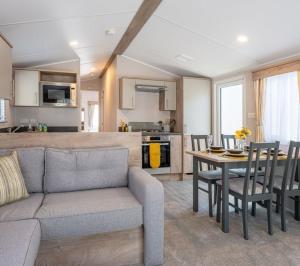 a living room and kitchen with a couch and a table at Sun & Sand, Near Padstow, Seven Bays, Sleeps 6 in Saint Merryn