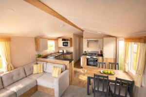 a living room and kitchen with a couch and a table at Sun & Sand, Near Padstow, Seven Bays, Sleeps 6 in Saint Merryn +6 photos