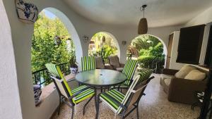 a dining room with a glass table and chairs at Chalet a 500m del mar in Altea