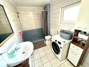 a bathroom with a washer and dryer in it at Apartment mit 4 Betten in Karben