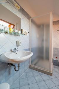 a bathroom with a sink and a shower at Főnix Fogadó in Lenti +19 photos