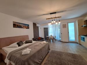 a bedroom with a large bed and a living room at Opium STUDIO ALEZZI in Mamaia Sat/Năvodari +29 photos