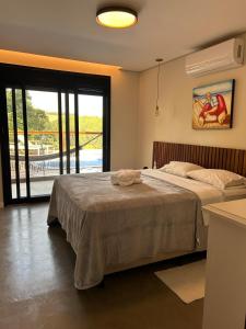 a bedroom with a large bed and a large window at Casa campo moderna e confortável in Itatiba +40 photos