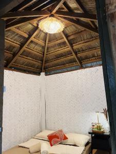 a room with two beds and a ceiling with a chandelier at Coron Cozy Nature Hut in Coron