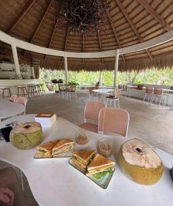 a white table with sandwiches and bread on it at Coron Cozy Nature Hut in Coron