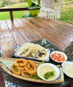 a tray of food on a table with onion rings at Coron Cozy Nature Hut in Coron