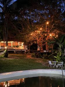 a backyard with a pool at night with lights at Coron Cozy Nature Hut in Coron +23 photos