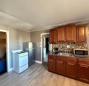 a kitchen with wooden cabinets and a counter top at Pineapple Inn in North Attleboro +13 photos