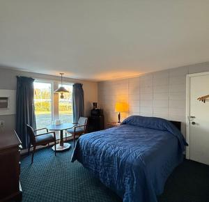 a bedroom with a bed and a table in it at Pineapple Inn in North Attleboro