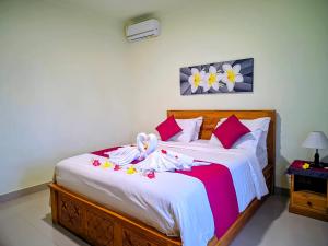 a bedroom with a bed with dolls on it at RR Cottage in Nusa Penida