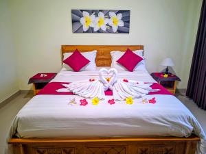 a bed with two swans made out of towels at RR Cottage in Nusa Penida +49 photos