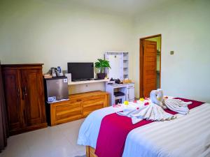 a bedroom with a bed with a swan on it at RR Cottage in Nusa Penida