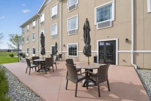 a patio with tables and chairs in front of a building at Cobblestone Hotel & Suites - Eaton in Eaton +89 photos