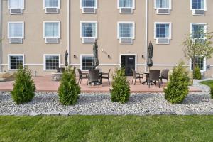 a building with tables and chairs in front of it at Cobblestone Hotel & Suites - Eaton in Eaton