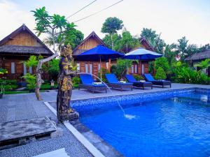 a pool with a statue next to a house at RR Cottage in Nusa Penida