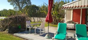 a patio with a table and chairs on a deck at Cabana Papoila in Colares