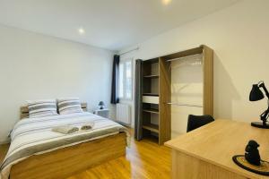 a bedroom with a large bed and a desk at Cognac Gare Classé 3 in Cognac