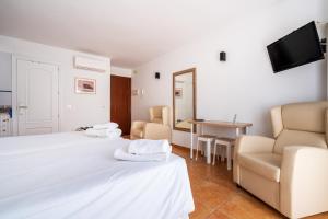 a hotel room with two beds and a table at Apartamentos Capricho del Mar in Torremolinos