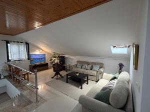 a living room with a couch and a tv at A CASA DE SISAN in Ribadumia