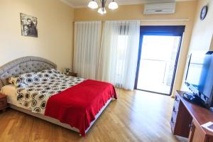 a bedroom with a bed with a red blanket and a television at Villa Narcissus Montenegro KO Sveti Stefan in Sveti Stefan