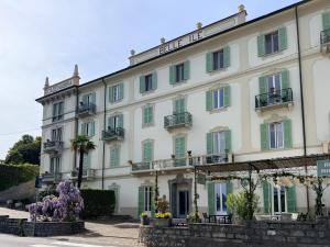 a large white building with green shutters at BELLE ILE LAKE VIEW SUITE in Griante Cadenabbia