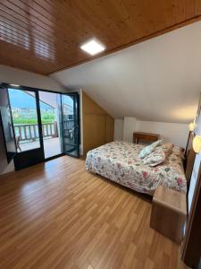 a bedroom with a bed and a sliding glass door at A CASA DE SISAN in Ribadumia +59 photos