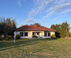 a white house with a red roof on a yard at Siedlisko Studzianki in Studzianki Pancerne +14 photos
