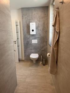 a bathroom with a toilet and a paper dispenser on the wall at Ferienwohnung Ruhepunkt Dessau - zentral nahe Bauhaus und Meisterhäusern - mit gratis WLAN und Parken sowie Komplettküche in Dessau +22 photos