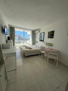 a bedroom with a bed and a table and a window at Casa climatizada in Playa Fañabe