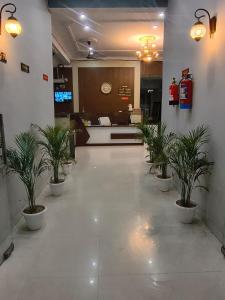 an empty lobby with potted plants in a room at Hotel Radhika Palace in Mirzāpur