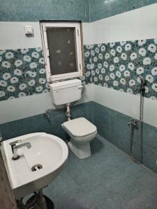 a bathroom with a toilet and a sink and a window at Hotel Radhika Palace in Mirzāpur +13 photos