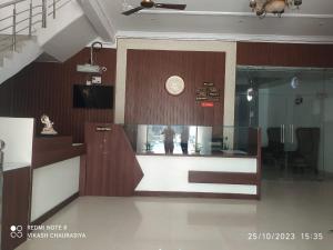 a room with a clock on a wall with a counter at Hotel Radhika Palace in Mirzāpur