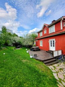 a red house with a wooden deck in the yard at 120 yrs. old log house in Kuopio city centre in Kuopio
