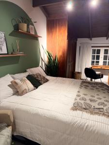 a large white bed in a room with a window at Chalé da Praia Paraty in Paraty