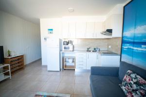 a kitchen with white cabinets and a couch in a room at Edificio Prieto VIV 4 in Puerto del Rosario
