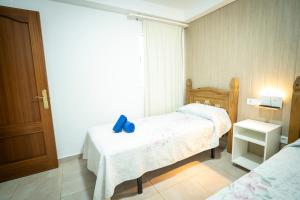 a bedroom with two beds and a blue ribbon on the bed at Edificio Prieto VIV 4 in Puerto del Rosario