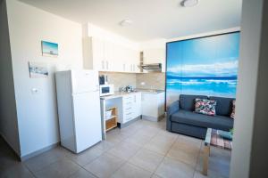 a kitchen with a refrigerator and a couch in a room at Edificio Prieto VIV 4 in Puerto del Rosario