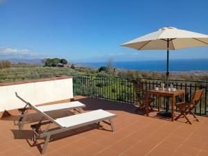 a patio with an umbrella and a table and chairs at MaNi Madre in Giarre