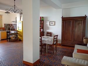 a living room with a table and chairs and a kitchen at MaNi Madre in Giarre