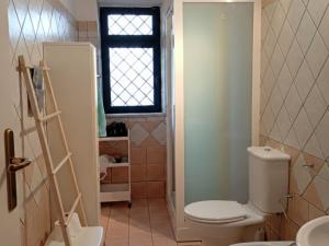 a small bathroom with a toilet and a window at MaNi Madre in Giarre