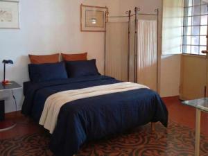 a bedroom with a bed with a blue comforter at MaNi Madre in Giarre
