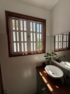 a bathroom with two sinks and a window at Chalé da Praia Paraty in Paraty +87 photos