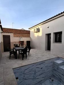 a patio with a table and chairs next to a building at La Jara Rosa in Los Navalucillos