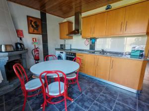 a kitchen with a table and chairs and a sink at Malhadinhas House in Vila Nova de Paiva +5 photos