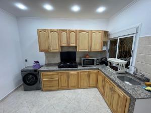 a kitchen with a sink and a microwave at Lixus Appartement- 1h Stadion & Airport Tanger in Larache
