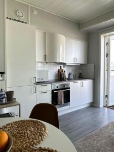 a kitchen with white cabinets and a table at Mountain and Sea View Svolvær in Svolvær +18 photos