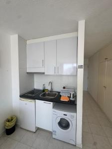 a kitchen with a sink and a washing machine at Casa climatizada in Playa Fañabe +3 photos